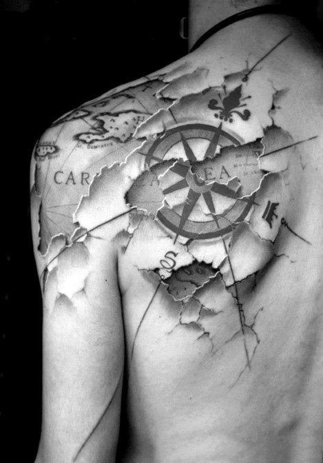 3D compass tattoo on shoulder and upper back with torn skin effect, revealing a vintage map and nautical elements underneath.