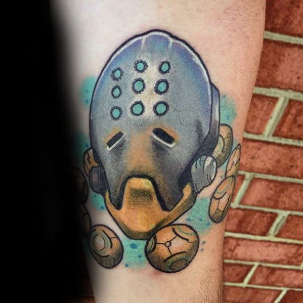 Colorful tattoo of Zenyatta from Overwatch, featuring his robotic head and floating orbs on a man’s forearm.