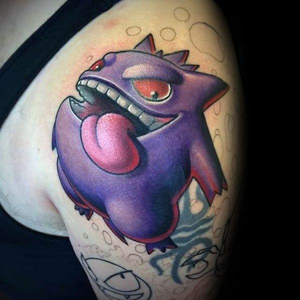 Playful Gengar tattoo on the shoulder with exaggerated tongue, red eyes, and a vibrant, cartoonish 3D shading style.