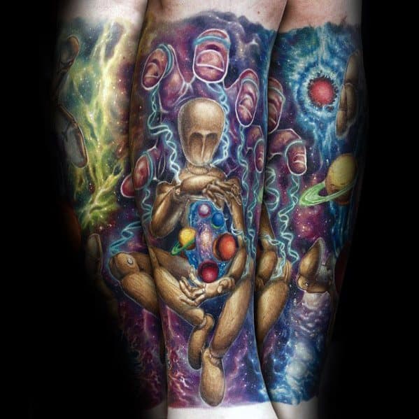 Vibrant cosmic puppet tattoo of a wooden mannequin holding planets with galaxy, stars, and energy swirls in the background.