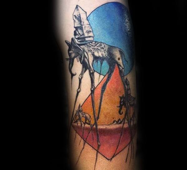 Surreal tattoo of Dali-style elephants with long legs, carrying obelisks, set against geometric shapes and a bold blue and orange background.