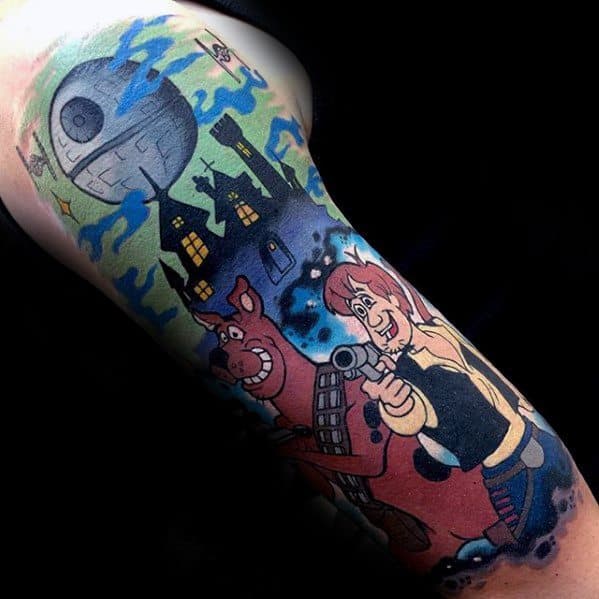 Tattoo of Scooby-Doo and Shaggy dressed as Han Solo and Chewbacca with a haunted house and Death Star in the night sky.