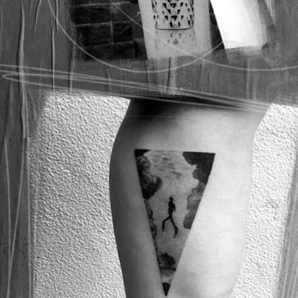 Minimalist tattoo of a scuba diver inside a black triangle, surrounded by soft clouds and water-like textures for a surreal effect.