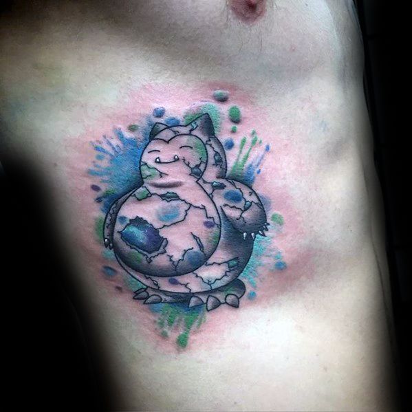 Watercolor-style Snorlax tattoo on ribcage with cracked stone texture and splashes of blue, green, and purple in the background.