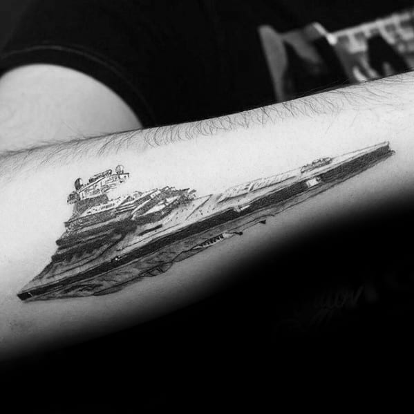 Realistic Star Destroyer tattoo on forearm, with fine line work and shading that adds depth and motion to the design.