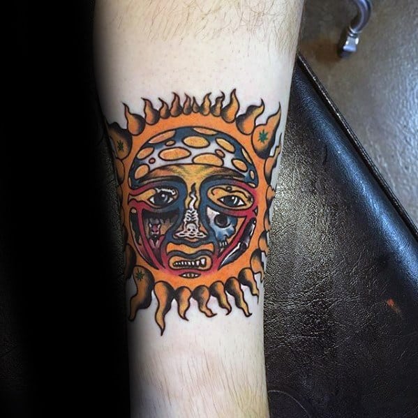 Vibrant sun tattoo with a melting face design, inspired by Sublime’s classic logo, placed on the inner forearm.