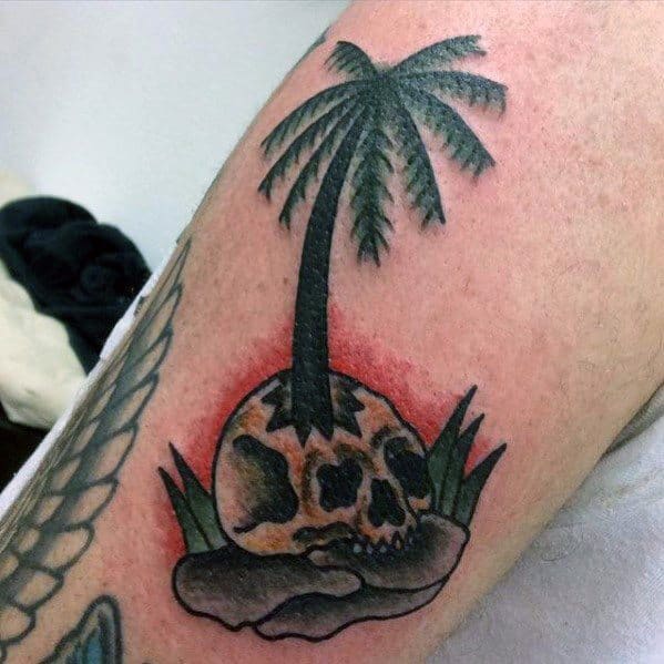 Palm tree tattoo growing out of a skull on a small island, combining tropical vibes with a dark, surreal twist.
