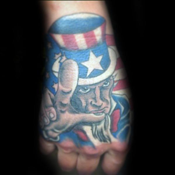 Colorful Uncle Sam tattoo on the hand with bold red, white, and blue tones, showing him pointing forward in a classic patriotic pose.