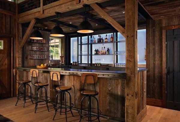 Rustic wooden bar with stools, bottles on shelves, and industrial pendant lights