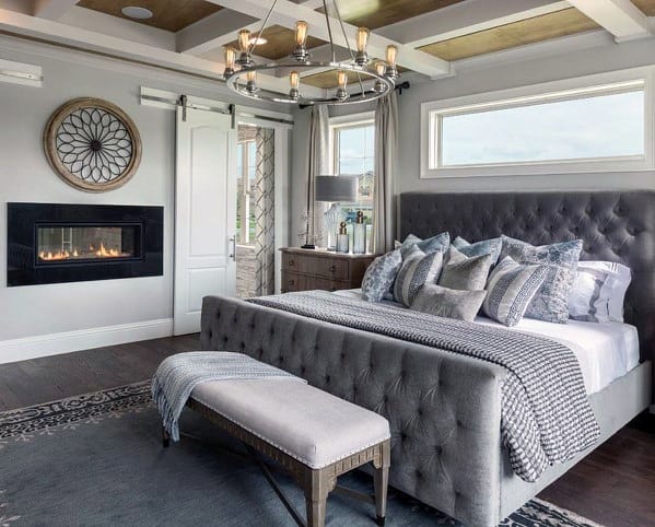 luxury master bedroom with fireplace and chandelier