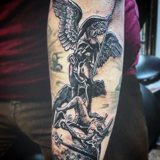 Forearm tattoo of an angel defeating a demon, with intricate details and shading
