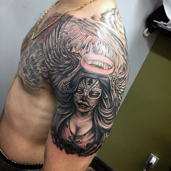 Tattoo of an angel with a halo on a man’s upper arm and shoulder