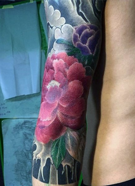 Colorful flower tattoo sleeve on a person's arm with detailed shading and highlights