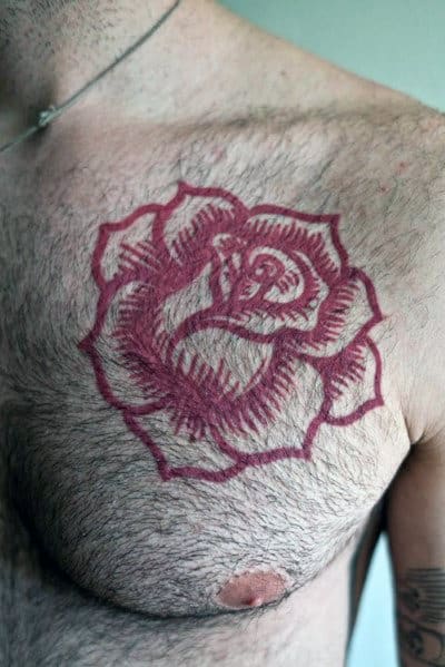 A chest tattoo of a rose outlined in red, featuring intricate shading and bold, clean lines
