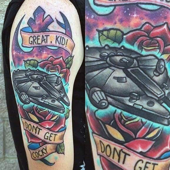 Colorful Millennium Falcon tattoo on the upper arm with roses, galaxy background, and the quote “Great, kid! Don’t get cocky.”