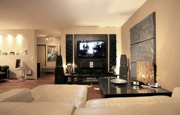 Modern man cave with a sofa, TV, art on walls, and sleek decor in warm lighting