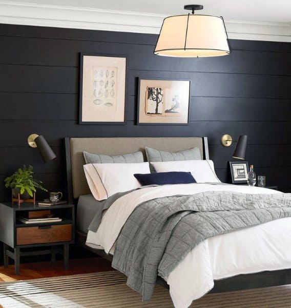 Modern bedroom with black shiplap wall, gray bedding, and stylish bedside lamps.
