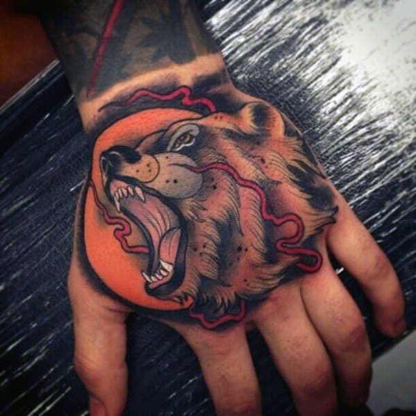 Neo-traditional bear tattoo on the hand featuring a roaring bear with a bold orange background and red lightning-like accents.