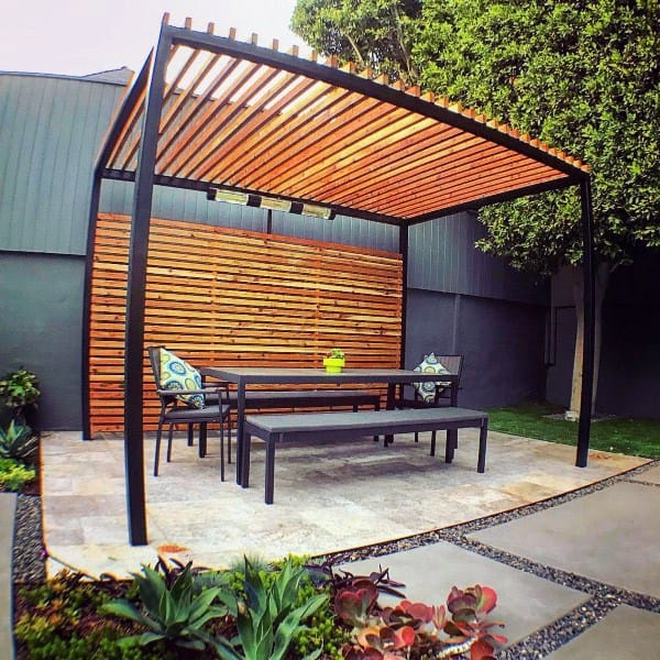 Sleek pergola with wood slats, black metal frame, outdoor dining set, and modern garden decor.