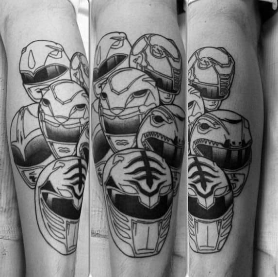 Black and grey tattoo featuring all classic Power Ranger helmets in a bold, stacked design across the forearm.