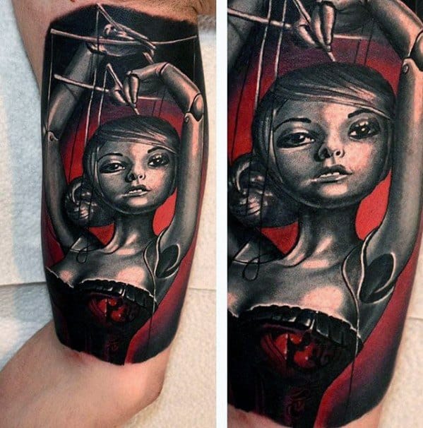 Realistic puppet tattoo of a female marionette with expressive eyes and strings, set against a bold red and black background.