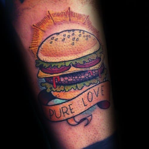 Tattoo of a cheeseburger with sun rays, lettuce, tomoato, and "Pure Love" on a banner