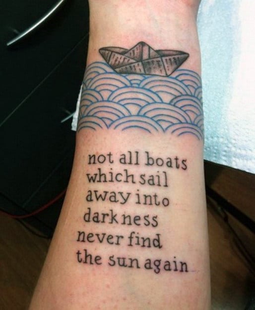 Tattoo of a paper boat on waves with text: "not all boats which sail away into darkness never find the sun again"