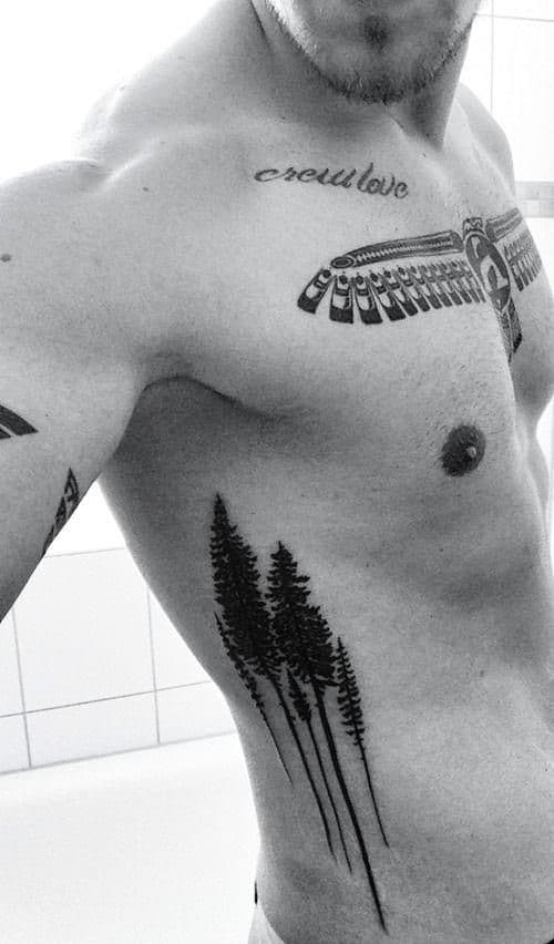 Side tattoo featuring tall, slender pine trees in a minimalist style
