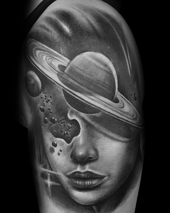 Black and grey Saturn tattoo design for men blending a woman's face with planetary rings, asteroids, and deep space elements.