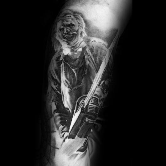 Black and grey tattoo of Leatherface from *The Texas Chainsaw Massacre*, featuring his grotesque mask and chainsaw for a dark and intense horror look.