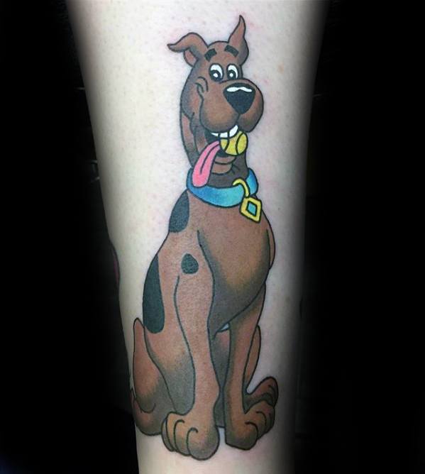 Tattoo of a happy Scooby-Doo sitting with his tongue out, wearing his signature blue collar and dog tag.