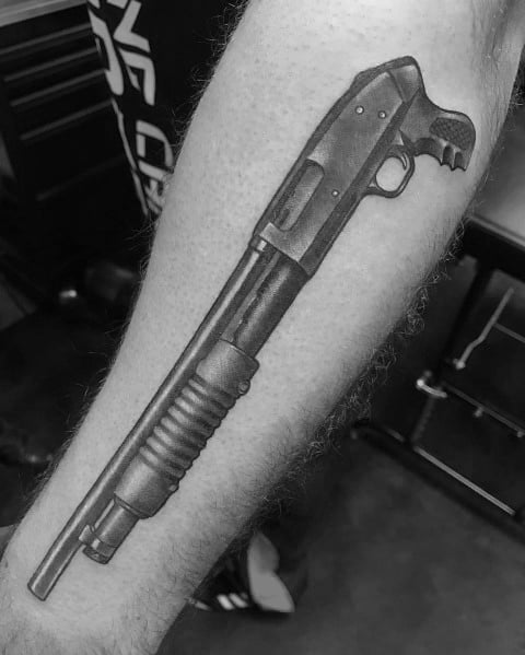 Realistic black and grey shotgun tattoo on the forearm, featuring detailed shading and depth for a bold, lifelike design.