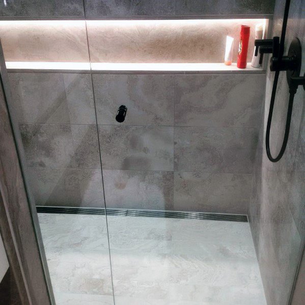 Elegant shower with sleek LED lighting illuminating a storage niche, creating a modern, soft ambiance