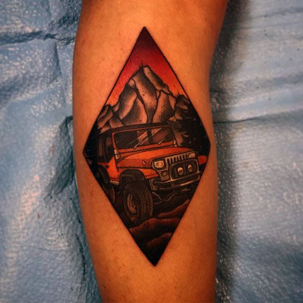 Colorful Jeep tattoo in a diamond-shaped frame, featuring an off-road Jeep against a mountain backdrop with a bold red and orange sunset sky.