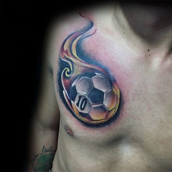 Colorful chest tattoo of a flaming soccer ball with the number 10, featuring dynamic fire effects and bold shading around the ball.