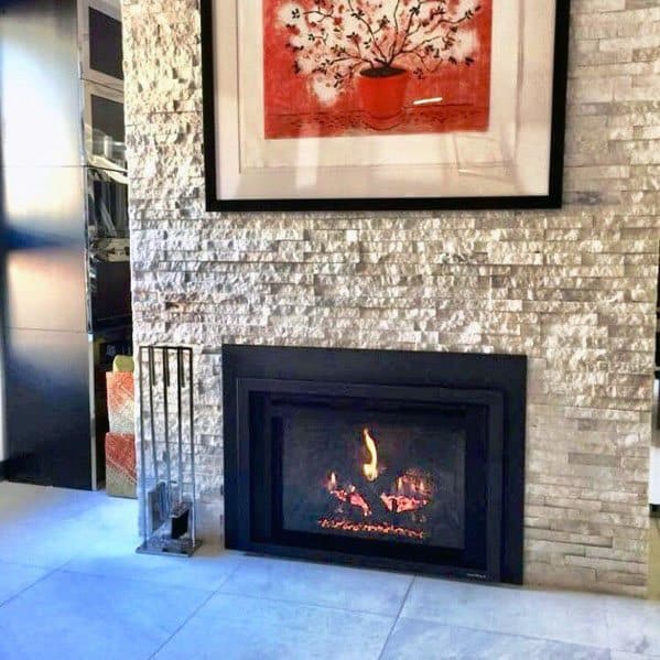 Cozy stacked stone fireplace with a modern black insert, complemented by bold artwork above