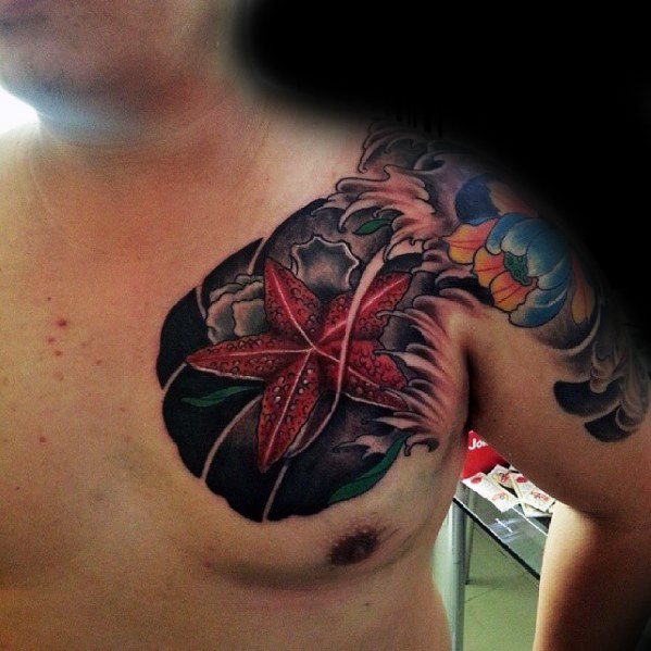 Bold red starfish chest tattoo with black waves and colorful shoulder design, blending ocean and traditional Japanese styles.