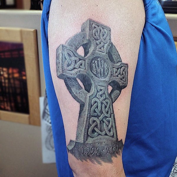 Tattoo of a Celtic cross on an arm with the inscription "1922 - 2008"