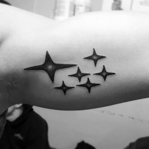 Black and grey Subaru logo tattoo on the inner arm, featuring six stylized stars representing the iconic Subaru emblem.