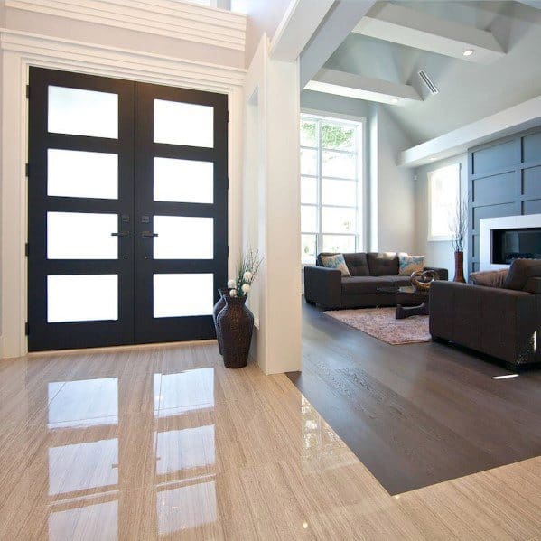 Sleek tile-to-hardwood floor transition in a modern entryway, combining glossy tiles with rich wood for a luxurious contrast