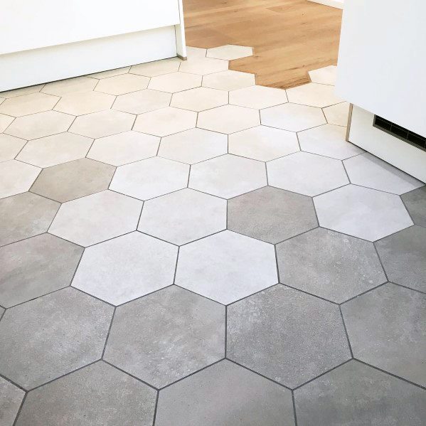 Hexagonal tile-to-wood floor transition blending grey tiles with natural wood for a seamless and contemporary design