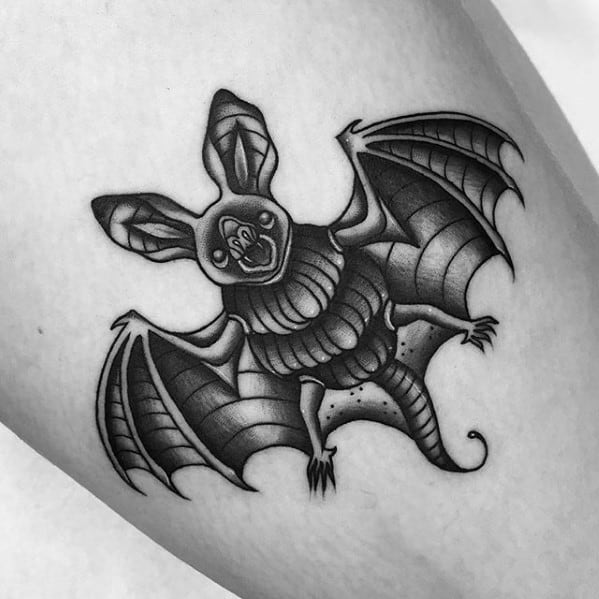 Traditional black and grey bat tattoo with exaggerated features, detailed linework, and bold shading on wings and body.