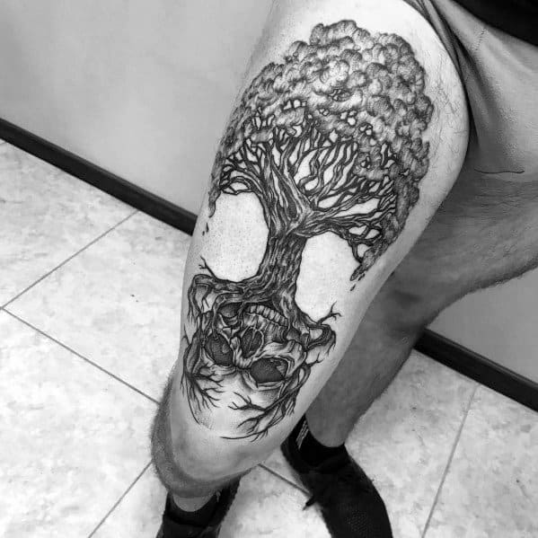 Black and grey thigh tattoo of a detailed tree with twisted branches and roots merging into a skull, symbolizing life, death, and transformation.