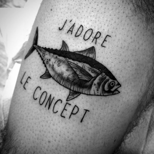 Black and grey tuna fish tattoo with "J'adore le concept" text, featuring bold outlines and shading for a classic, artistic design.