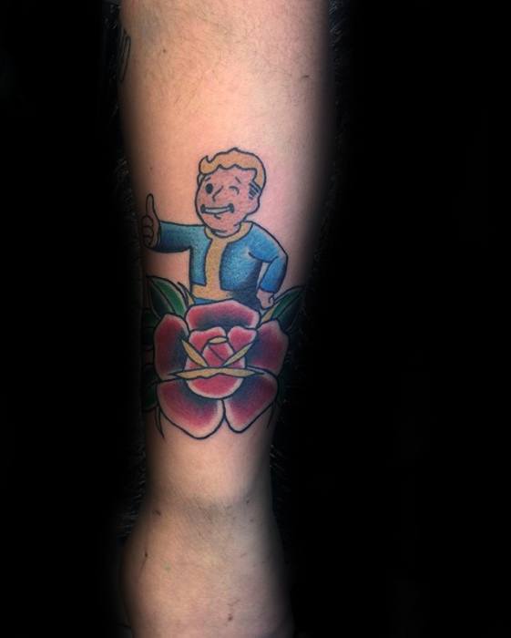 Vault Boy tattoo giving a thumbs-up above a bold red rose with green leaves, blending Fallout style with classic tattoo art.