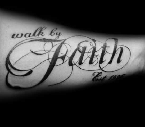 Tattoo with "Walk by Faith" in an elegant script, featuring bold flourishes and intricate lettering for a stylish and meaningful design.