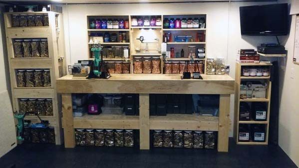 Custom reloading bench with wooden shelves, neatly stacked supplies, and an organized display of tools and components