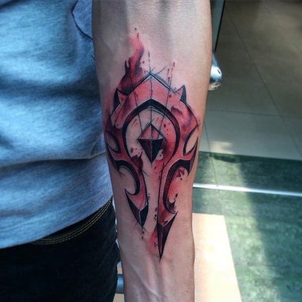 Sketch-style tattoo of the Horde emblem from World of Warcraft, featuring bold black lines with a red watercolor effect, inked on the forearm.