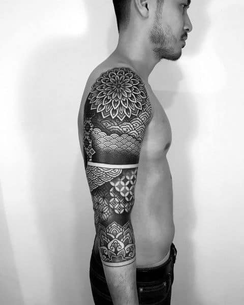 Black and grey full sleeve tattoo with intricate mandala, geometric, and wave patterns, symbolizing harmony, inner peace, and timeless balance.