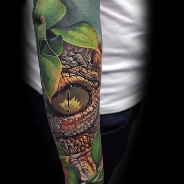 Hyper-realistic dinosaur eye tattoo peeking through green leaves, symbolizing primal instincts, power, and connection to nature.